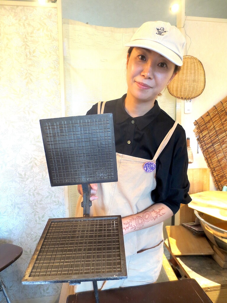 和田絵三子さん。手にしているのは、格子せんべいの型。
