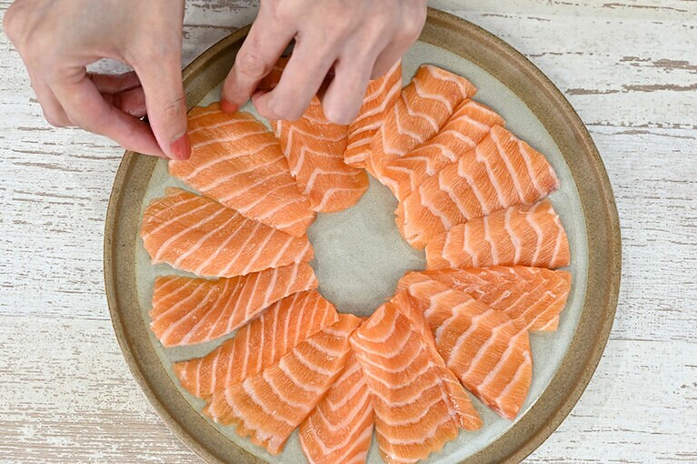 手際よくカットしたノルウェーサーモンをカルパッチョ用に円形に並べていく。「この上に玉ねぎとアボカドを乗せていきますが、盛り付けで立体感を出すと料理の見栄えが格段によくなります」