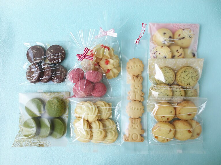 右上から時計まわりに：「クランベリーのクッキー」「サクサク紅茶クッキー」「オレンジとレモンのクッキー」「動物クッキー」「ヴィエノワ」「抹茶クッキー」「アーモンドのショコラクッキー」「生クリームクッキー」以上すべて各180円。まんなかのピンクの「苺のころころクッキー」は200円。