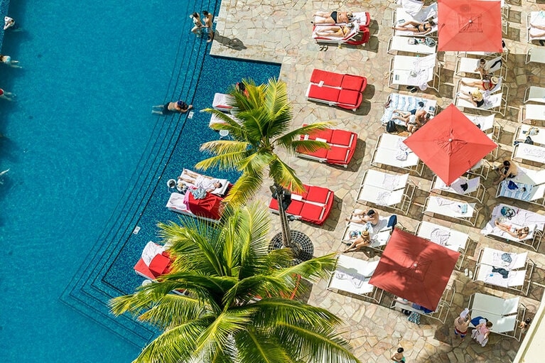 “インフィニティ・エッジ・プール”のプールサイドには赤いパラソルが開く。