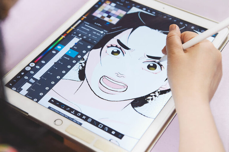 愛用のiPad Proを使う東村さん。「紙のマンガだと基本は白黒なので、セリフでは『真っ赤なワンピース』と言っていても、頭の中で白黒に変換してから絵に落とし込む。縦スクはオールカラーなので、その作業から解放されて、最初に思いついたままの色で作品を見てもらえるのが楽しい」 ©2020-2022, Higashimura Akiko, neostory, All rights reserved.