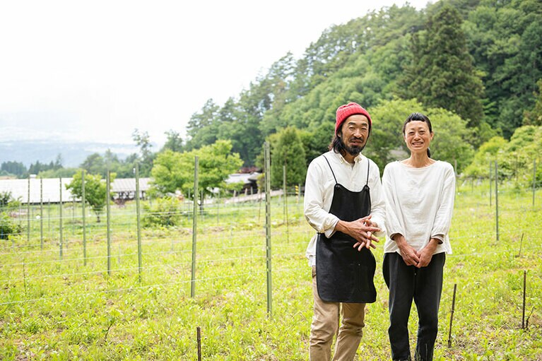 ブドウ畑を前に、種田さん夫妻。