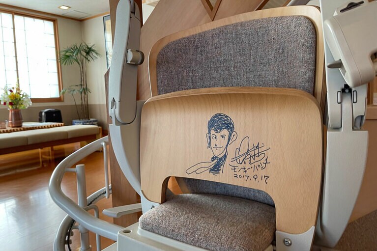 ロビーから2階へと続く階段の昇降機に、故モンキー・パンチ氏直筆のイラストとサインがある！