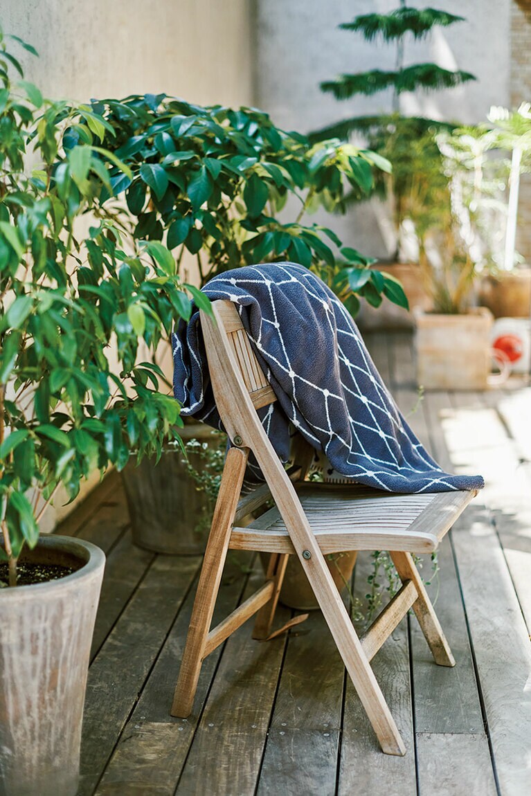 テラスには木製のチェアを置いて。ブランケットがインテリアの一部になり、冬でも心地いい時間が流れる。