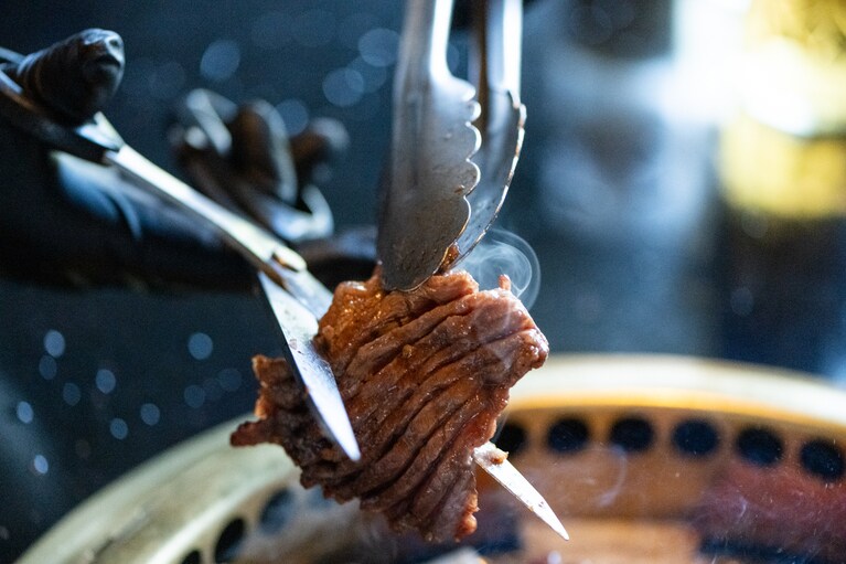 甘めの味付けが食欲をそそる雪花味付けカルビ（73,000ウォン）。スタッフが炭火で一枚一枚丁寧に焼いてくれるのも心強いポイント。