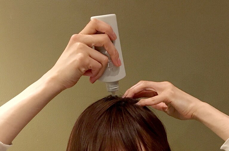 ノズルの先端を頭皮にあてて、適量を出しながらなじませていきます。