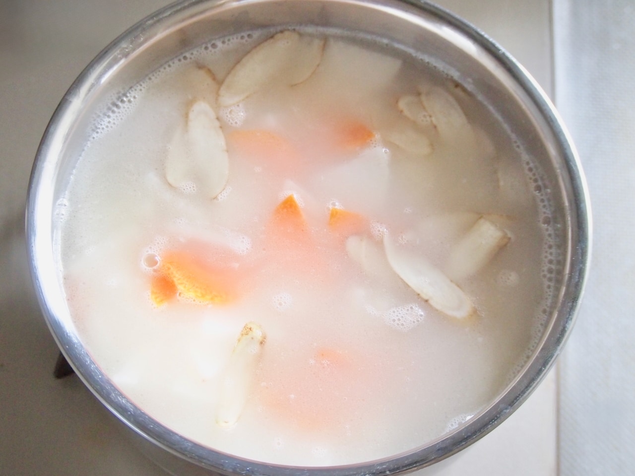 漉したスープを鍋に戻し入れ、（4）の大根、人参、ごぼう、取り出しておいた鯛の身を入れて加熱する。