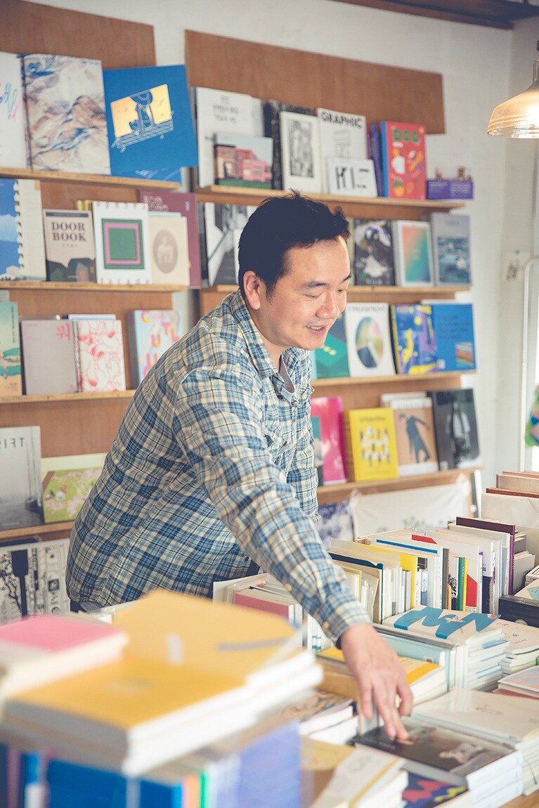 代表のカンさん。「独立出版本の魅力は、既成のルールにとらわれず表現できること。作り手の思うように制作できるメディア」と語る。制作段階からバックアップしたり、自身が写真家となってポストカードシリーズを制作したりと、フィールドは広い。店にはエッセイやマンガなど読み物と大型本が中心。近くにオープンした二号店では写真集も多く扱う。