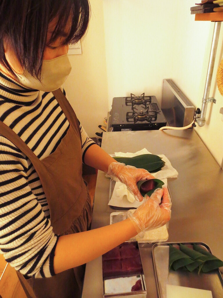 朝、ういろうを笹でていねいに包む高崎恵さん。