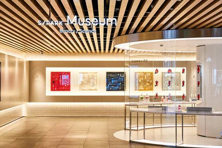 【資生堂グローバルイノベーションセンター S/PARK(エスパーク)】2階への階段を昇るとまず目に飛び込んでくるのが、資生堂コスメのルーツともいうべき化粧水オイデルミンのブース(右手前)と、製品のパッケージデザインを色ごとに分類した展示(奥)。その美しさ、愛らしさに心を奪われます。