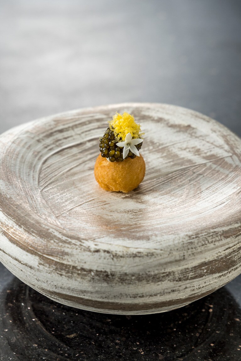 メインダイニング「MUGEN」のめくるめく美食の一皿「ササニアン・オシェトラ・キャビア」。キャビアの下には、ハワイのソウルフードとしてお馴染みの “アンダギー” が。