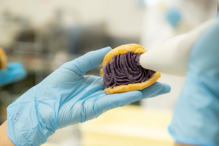 シュー生地に、甘みと香りの強い久米島産沖夢紫のクリームをたっぷりと詰めてゆく。