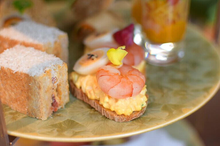 マヨネーズであえた卵をベースに、海老と黒胡椒をトッピング。エディブルフラワーの飾りが華やか。