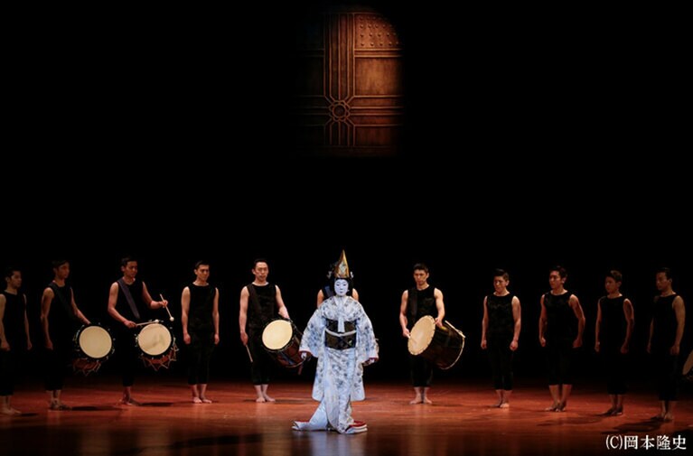 『道成寺』。烏帽子をつけた白拍子花子と背後には桶太鼓を演奏する鼓童のメンバーたち。演奏はもちろん、美しいフォーメーションを描く様子も見応えあり。