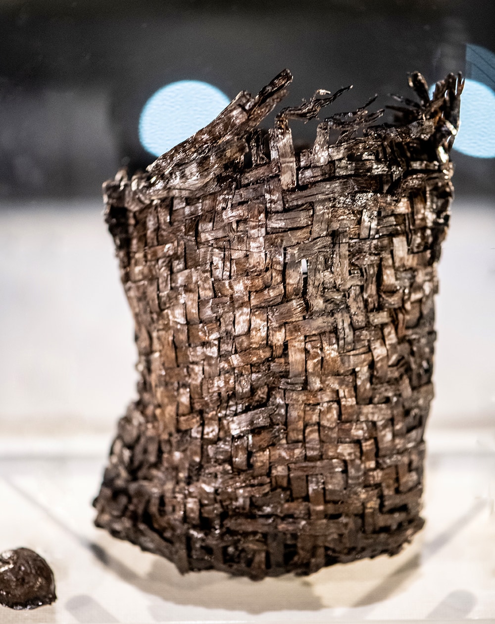 「縄文ポシェット」と呼ばれる木製編籠と中に入っていたクルミの殻。これを腰にさげて森を歩いていたかもと想像するだけで心躍る。現代にも受け継がれている波形網代編みで、素材はヒノキ科の樹皮。