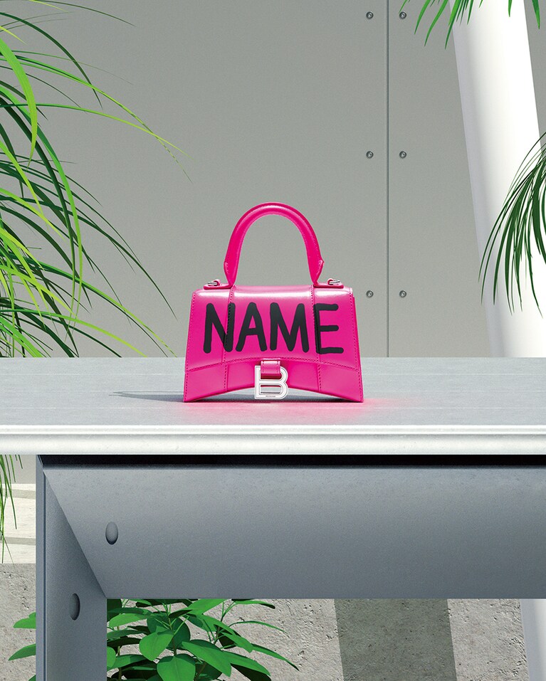 名前をカスタマイズ。HOURGLASS TOP HANDLE XS Acid Fuchsia 高さ13cm×幅19cm×奥行8cm 150,000円。／バレンシアガ(バレンシアガ ジャパン)