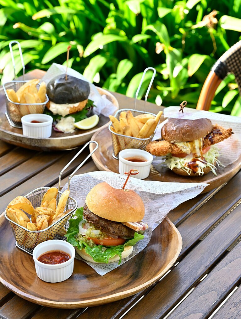 手前から、旨みが溢れる“MANZAクラシックバーガー” 3,000円、サクサク食感の“アグーカツレツバーガー” 2,900円、竹炭バンズを使った“フィッシュバーガー” 2,800円。