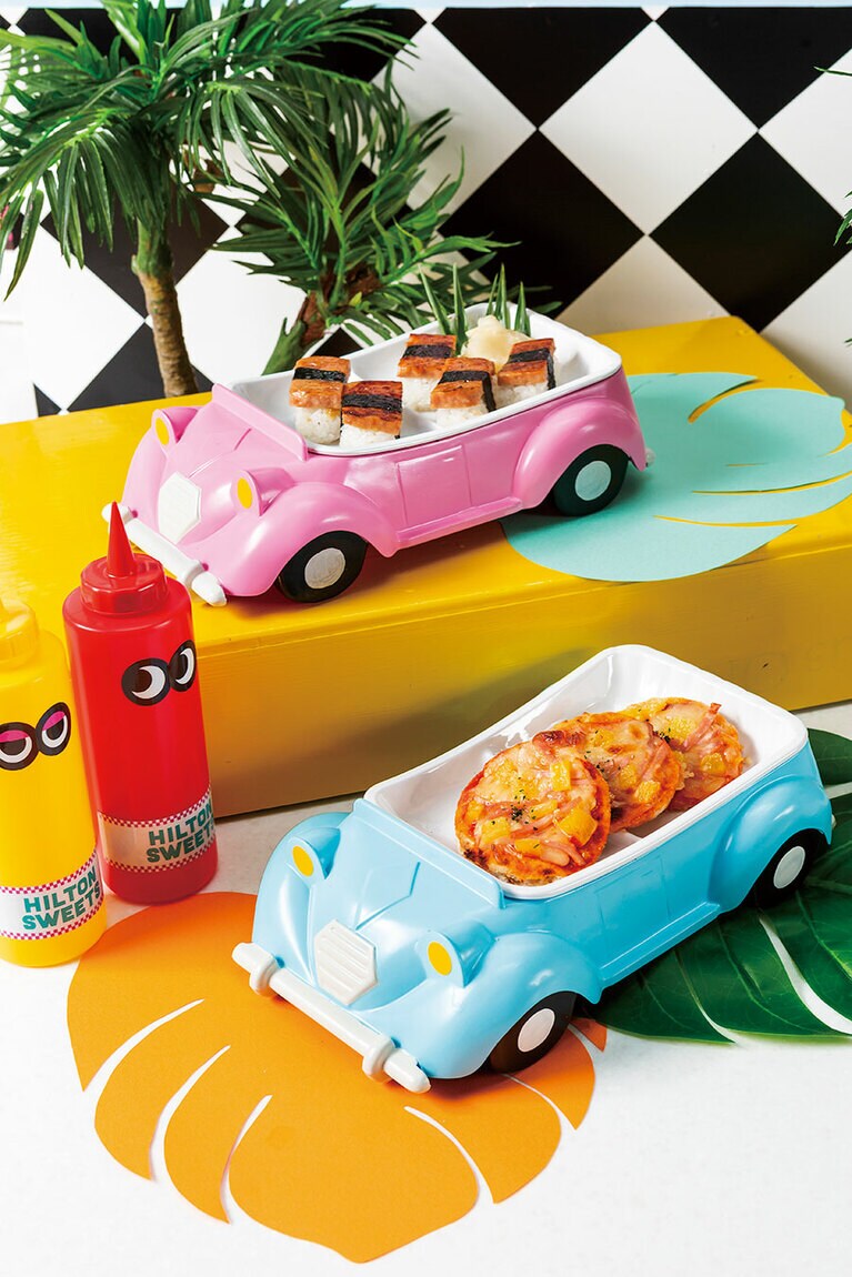 ハワイの伝統的な軽食「スパムにぎり(写真奥)」と、パイナップルをのせたトロピカルで少し甘めのピザ「パイナップルとハムのピザ(写真手前)」。