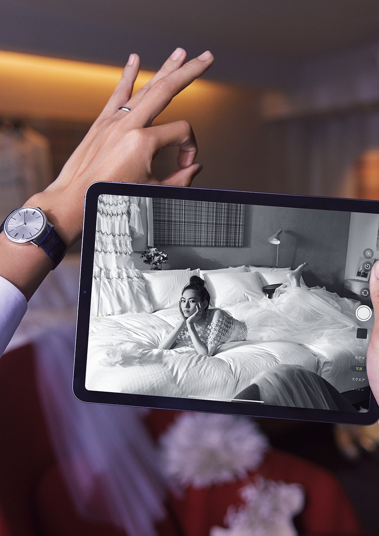 ［彼女］ドレス 330,000円(レンタル価格)、990,000円(販売価格)、ケープ 55,000円(レンタル価格)、187,000円(販売価格)／ともにリーム・アクラ、壁に掛けたドレス 352,000円(レンタル価格)、748,000円(販売価格)／テンパリー・ロンドン(すべてノバレーゼ銀座)、リング(WG×DIA) 1,650,000円／ブシュロン(ブシュロン クライアントサービス)、壁に掛けたジャケット 52,910円(レンタル価格)／クリオ オム(クリオ マリアージュ)、 ［彼］時計(WG×DIA×アリゲーターストラップ、ケース径35mm) 3,168,000円、リング(PT) 180,400円／ともにピアジェ(ピアジェ コンタクトセンター)