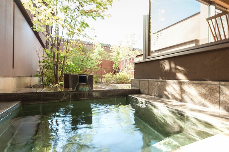 客室で温泉を楽しめる贅沢。見上げれば、澄み切った信州の青空が。