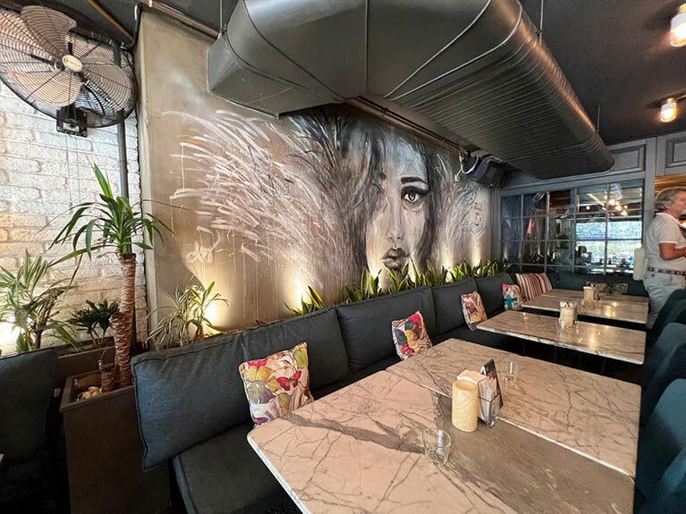 壁の大胆な絵が印象的なテーブル席。