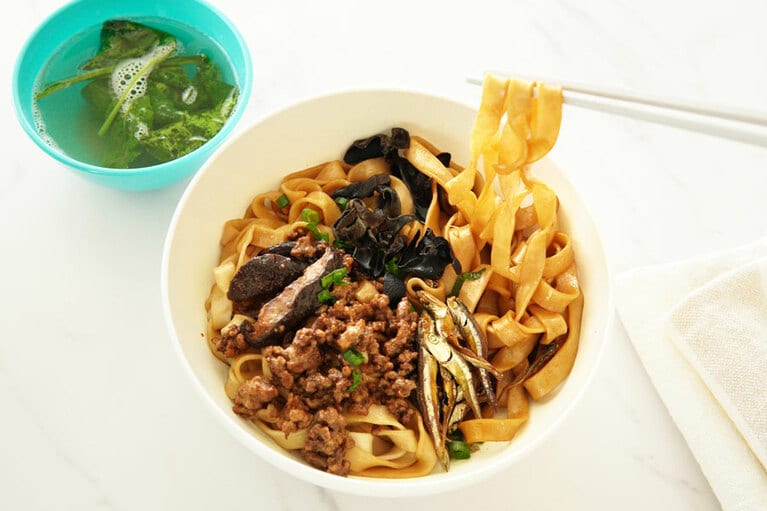 袋の指示どおりに麺をゆで、タレをからめたら、具をトッピングして完成。スープは別の皿に盛りつけ、麺にすこしずつかけながら食べるのが現地流。