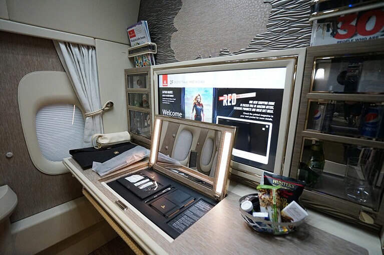 テーブルの一部を開けると鏡台になり、その中にはコスメと、「モレスキン」のノートとペンが。大型のモニターの両脇にはプライベートミニバーがある。