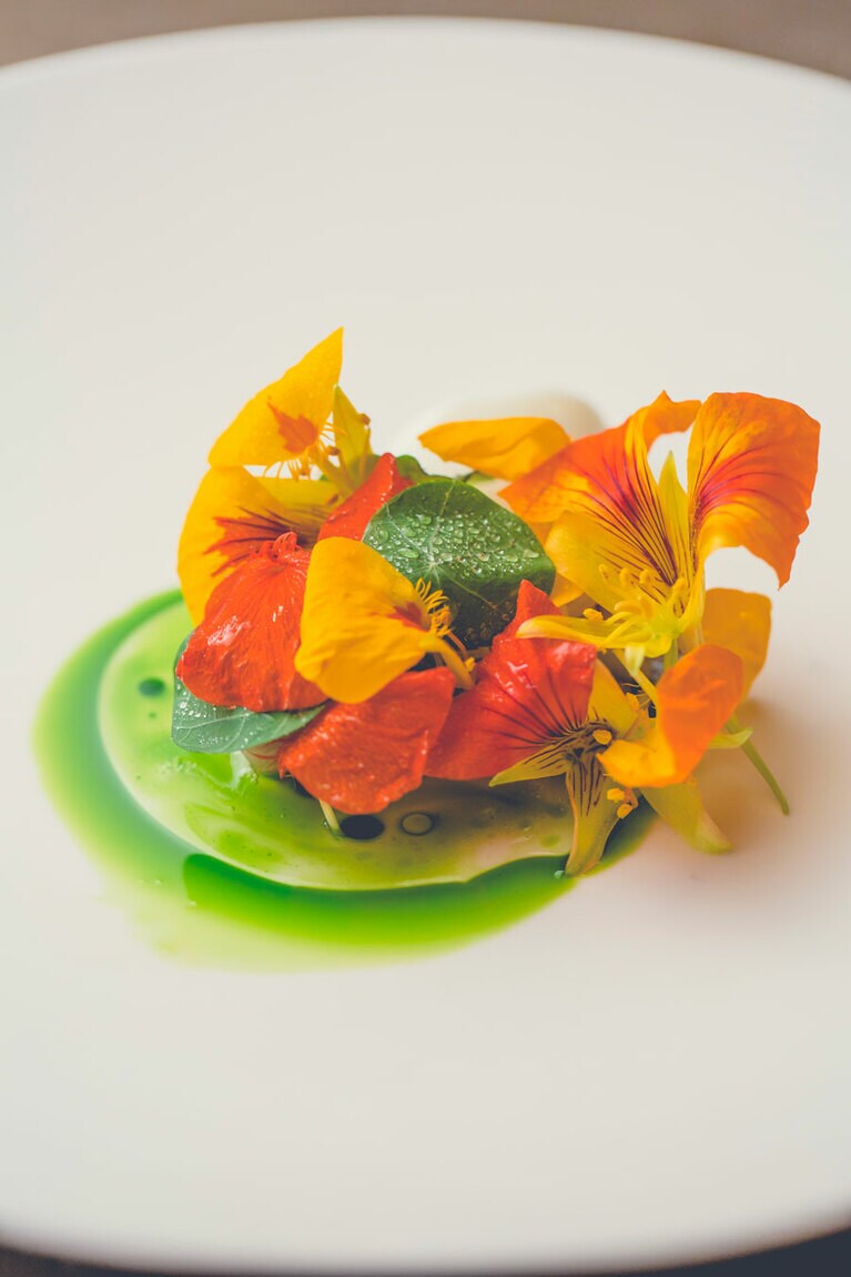 「サバ／ホエー／レンブ」。藁焼きしたサバに昆布や酢を使ったホエーのソースを添えた味は〆サバ風。「レンブ」は、台湾でワックスアップルとも呼ばれる果実。あえて食用花・ナスタチウムで飾り、味と見た目のギャップを楽しむ。