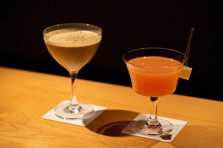 左の「ピスタチオ＆エスプレッソ」は、米焼酎「大石」や阿蘇の牛乳、エスプレッソなどを使ったデザートカクテル。「焼酎に苦手意識がある方にも飲んでほしい」と木場さん。右はテキーラベースの「スリーディレクションズ」。天・地・未来を意味する素材が使われていて、ストーリーを感じられる一杯に。