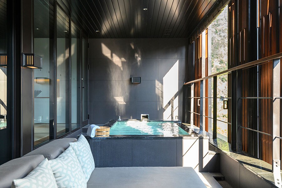 客室タイプ「月見」の温泉フロアには露天風呂の隣にゆったりと寝転がれるソファを完備。