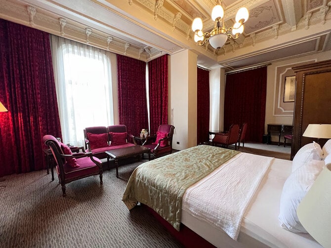 客室は天井が高く高級感がある。ボルドー色のカーテンや家具が華やかだ。