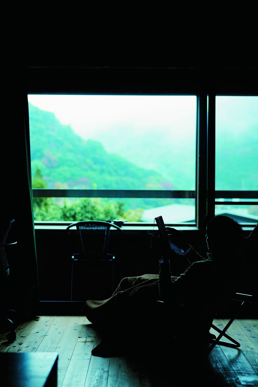 【養生館はるのひかり】湯坂山や塔ノ峰を望む、テラスが付いた洋室のひとり部屋で。Photo: Takafumi Matsumura