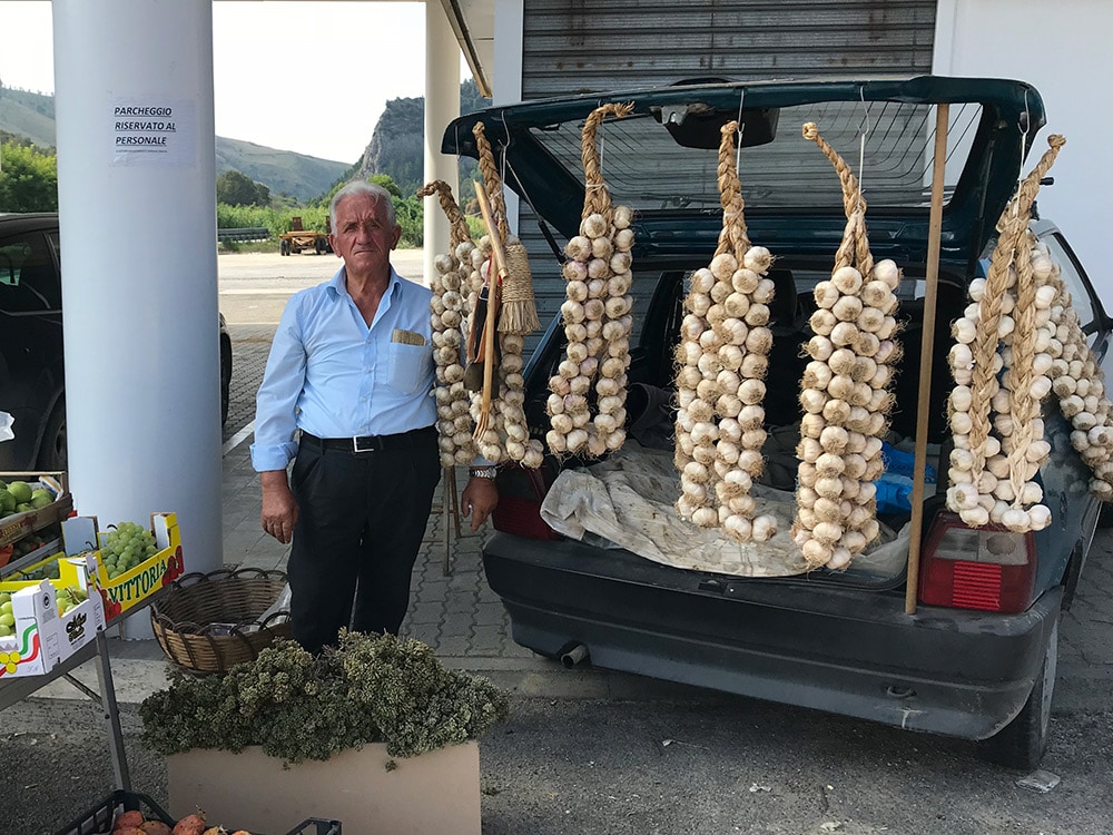“すだれニンニク”をぶら下げた農産物の直売は、シチリアの街道沿いでしばしば遭遇する。かつては馬車で運んでいたのだろうか？