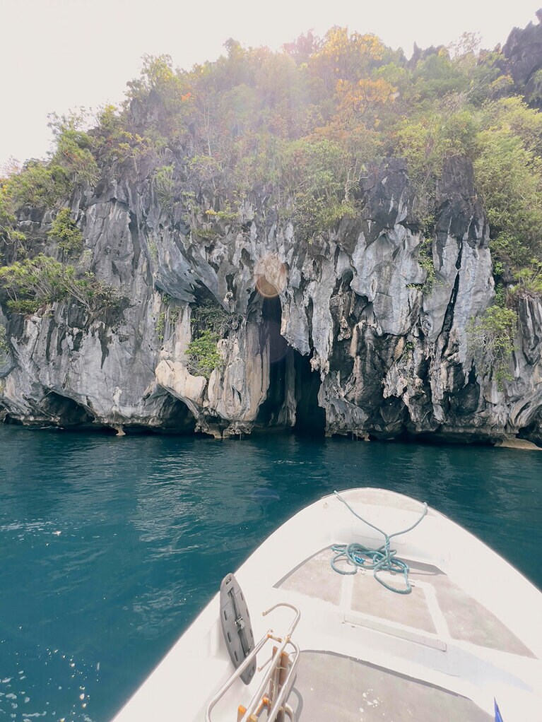 中央の小さな割れ目がピナシルケーブの入り口だ。海面近くの岩は、波で削られて浮いている。