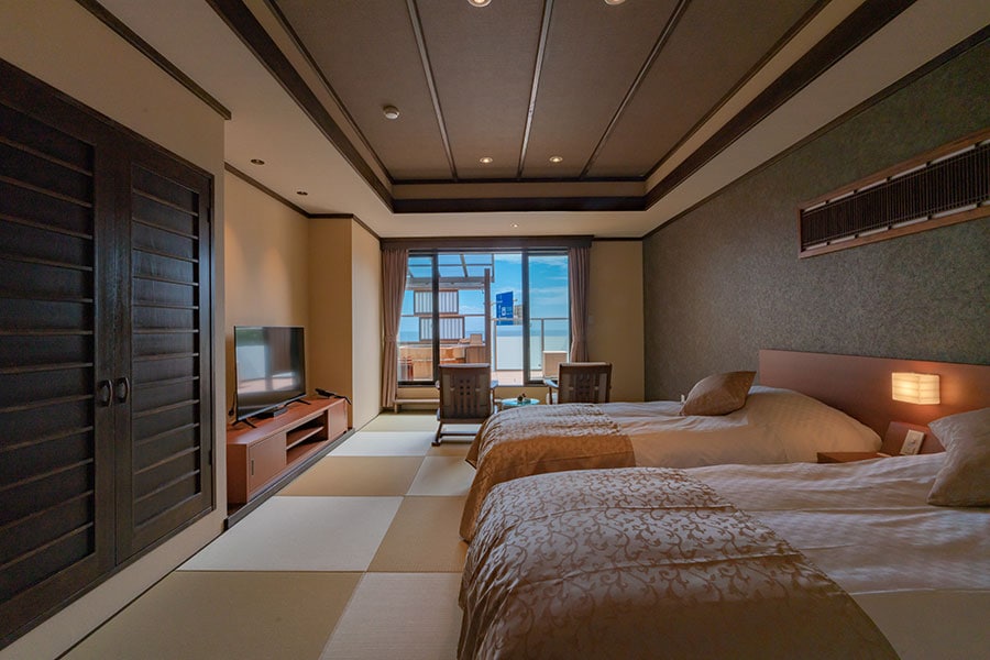 客室の一例。琉球畳が敷かれた和モダン⾵の空間デザインで、しっとりとした趣がある。