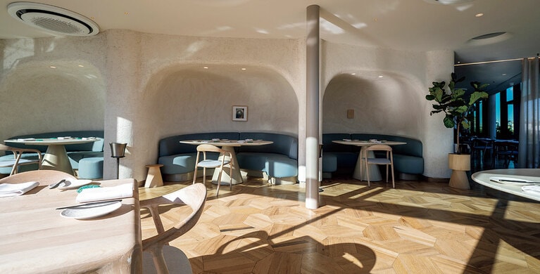 テラス、屋内席どちらも日が差し込む空間に。床はワイン樽の古材、壁には米の籾殻など使われている。