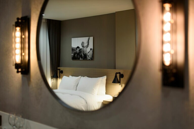 映画スターたちが使用するメイクルームをイメージした洗面台。ベッドの壁には映画のワンシーンのポスターが。