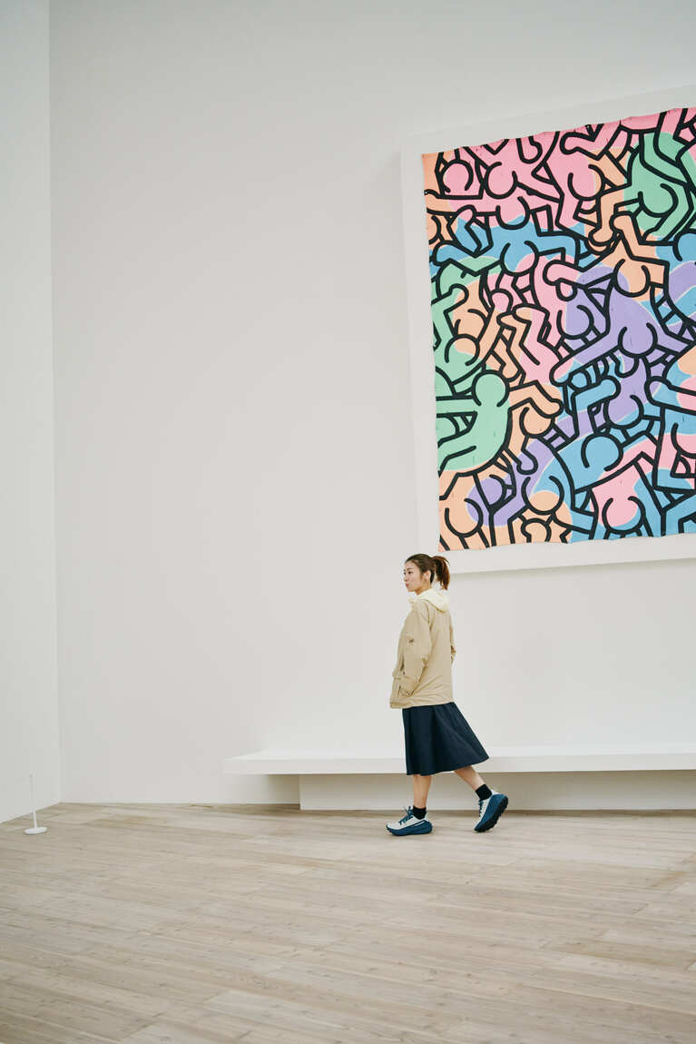 カーディガン（ハイランド ウィンドブレーカー カーディガン アジアンフィット）22,000円、フーデットジャケット（ハイキング ウィンドブレーカー フーデッド ジャケット アジアンフィット）17,600円、スカート（ハイランド トラベラー スカート アジアンフィット）18,700円、シューズ（エナジー ハイク ロー ゴアテックス）24,200円／すべてマムート、スタンドカラーシャツ18,700円／デミルクス ビームス(デミルクス ビームス 新宿 03-5339-9070)All Keith Haring Artwork ©Keith Haring Foundation、Courtesy of Nakamura Keith Haring Collection