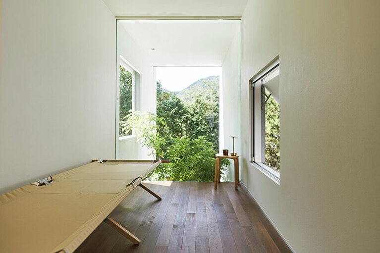 ゲストルームにもなる離れの2階。デイベッドに寝転んで考えごとをするのも、井上さんにとって大切な時間。右側の窓からは家族の気配を感じられる。