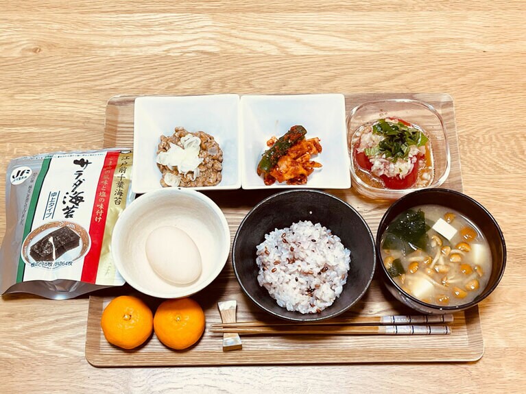 西嶌先生のある日の朝食。納豆、キムチ、なめことわかめの入った味噌汁、フルーツなど、プロバイオティクスとプレバイオティクスがたっぷり。
