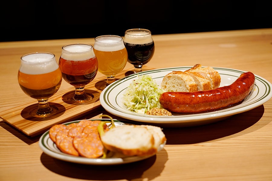小ぶりのグラスで4種類のビールを楽しめるテイスティングセットは1,200円。自家製ソーセージもいただくことができる。