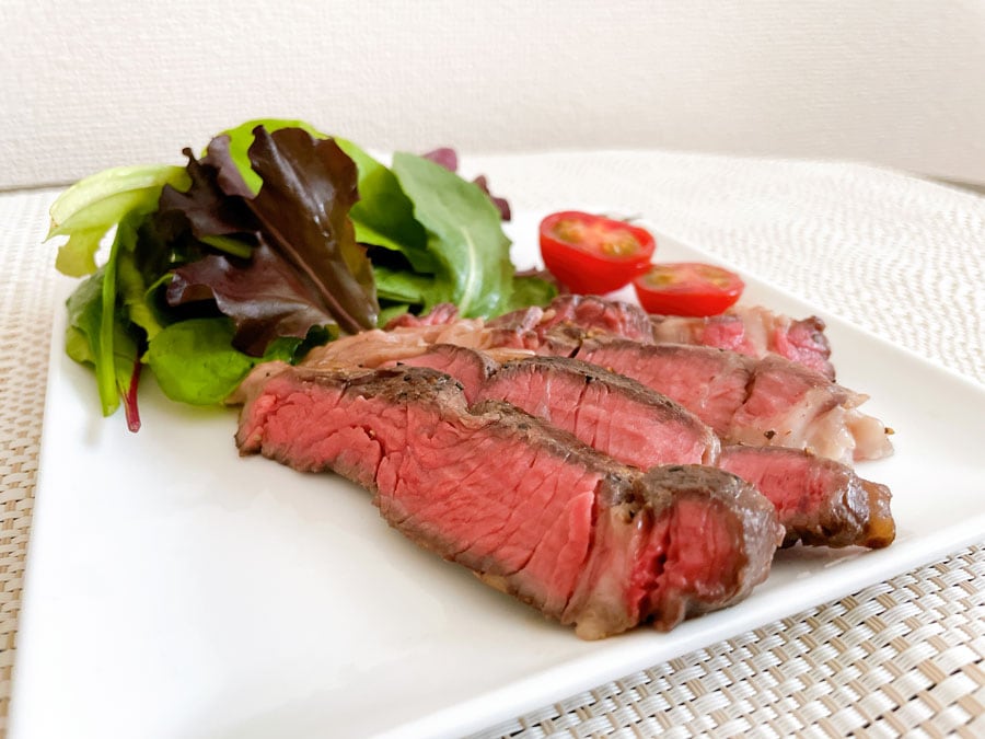 鮮やかな赤身が食欲をそそる牛ステーキに野菜も添えて。