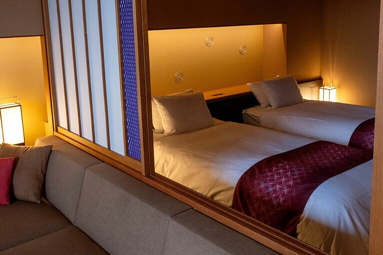 ベッドのヘッドボードや障子には加賀水引の美しい装飾が施されている。