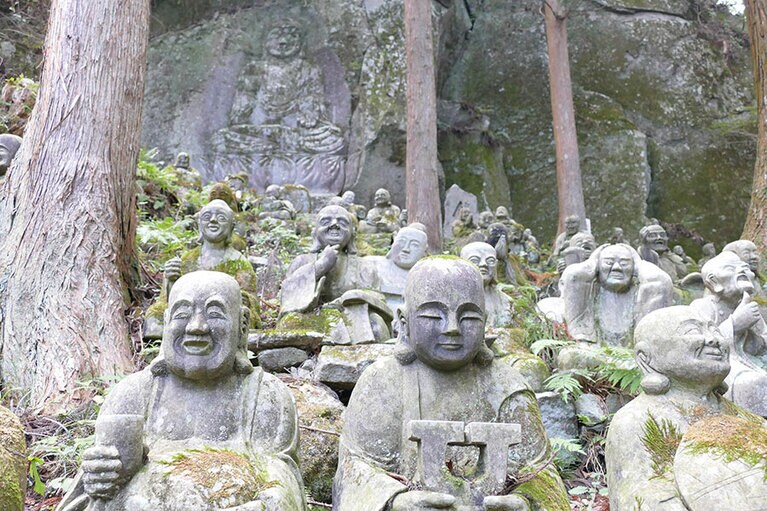 表情豊かな羅漢様と岩に彫られた麿崖仏様。手前の「U」は何かの頭文字？