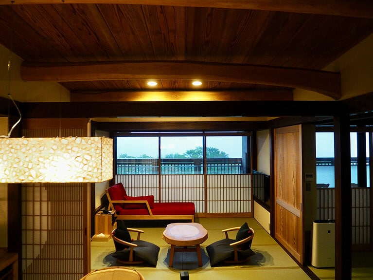 窓にはめ込まれた障子や引き戸などの建具も、匠の手によるもの。テーブルは天然木のカーブを生かしたオリジナル。