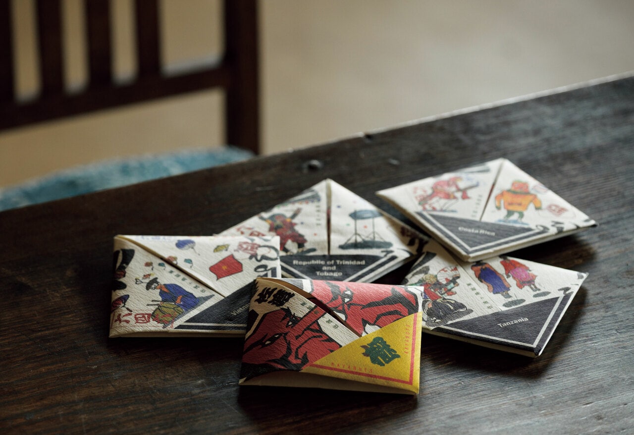 パッケージは1枚の和紙で包む日本古来の「折形」。イラストは佐渡の伝統的な祭りと、使っているカカオの産地の祭りがモチーフ。