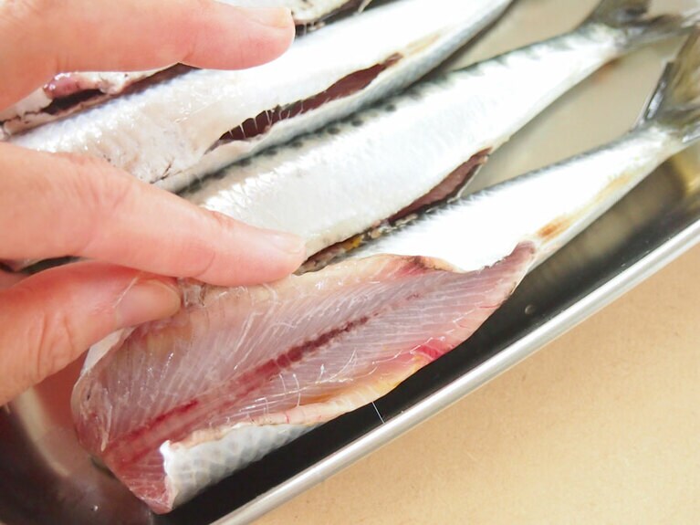(2) イワシは頭を切り落としたら、内臓を取り出し、お腹を水で洗います。