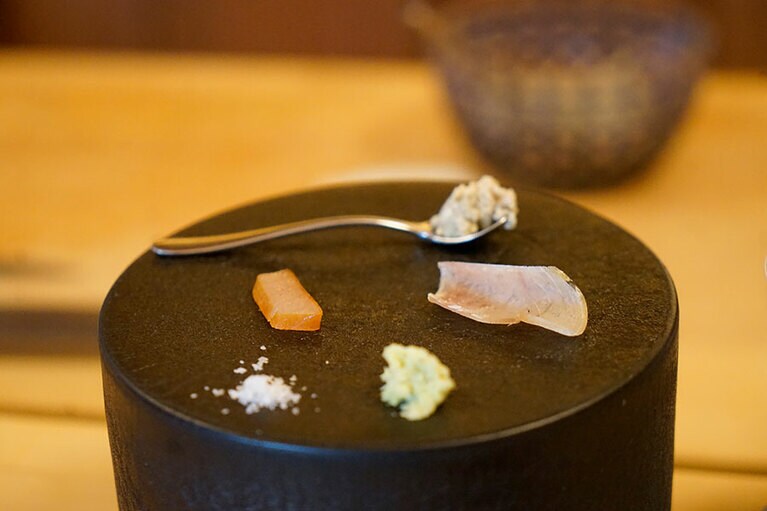 ブリの生ハム種。左が腹肉、右が背肉だ。高さのある黒い器は、同じ東岩瀬町にギャラリーをもつ陶芸家の釋永岳さん(次回でご紹介)の手による。