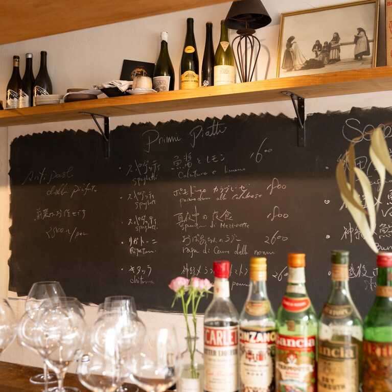 本日の料理が書かれた黒板と、スピリッツも並ぶカウンター。