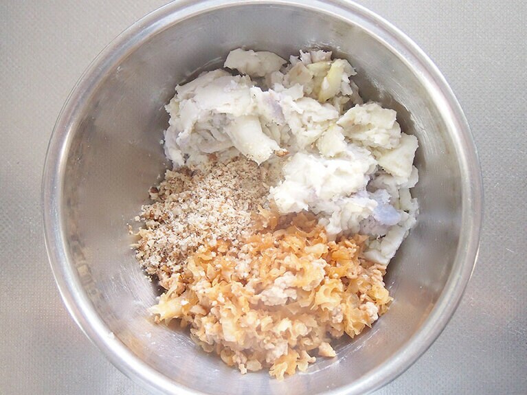 (4) ボウルに里芋を入れてフォークやマッシャーで潰します。(2)の具材、すり鉢で擦ったクルミ、塩を入れて全体をよく混ぜます。